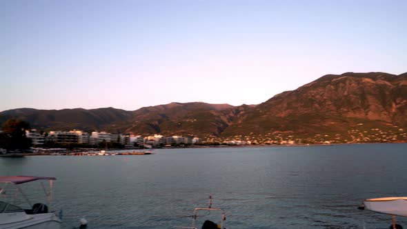 Wide pan shot of Kalamata sea, Taygetos mountain in the background, during golden hour, summer of 20