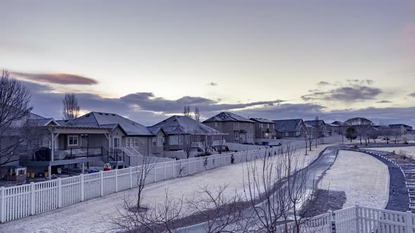 Static time lapse of a snow, frosty suburban neighborhood with cloudsing overhead