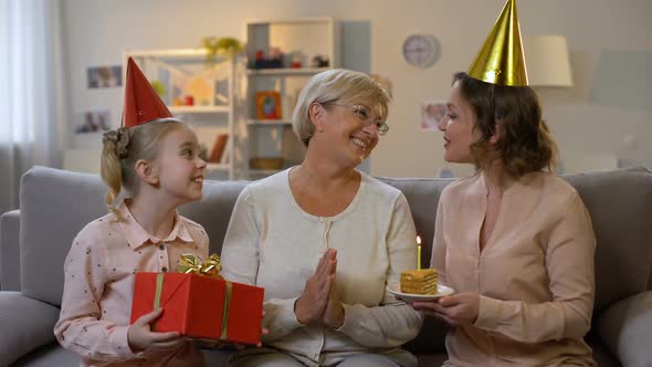 Female Kid and Mother in Party Hats Giving Present, Celebrating Granny Birthday