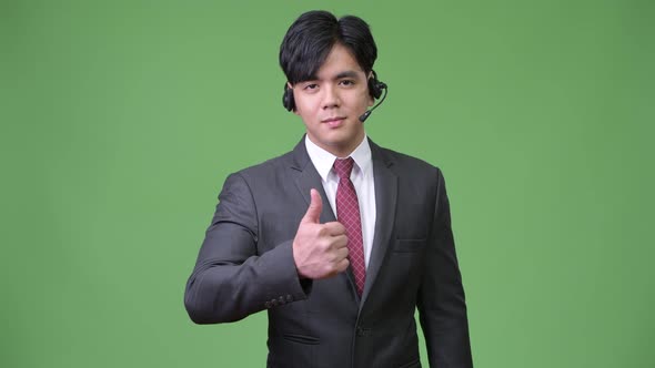 Young Handsome Asian Businessman Working As Call Center Representative