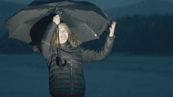 Woman Enjoys Rainy Weather Near River in Evening Slow Motion