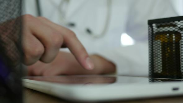 Doctor Typing On Tablet In Hospital