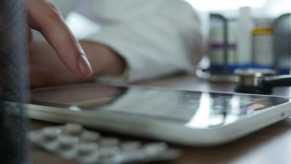 Doctor Typing On Tablet In Office alt