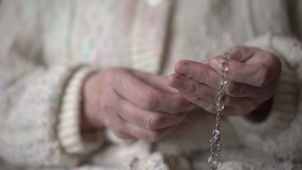 Female Hands Praying With Crystal Rosary