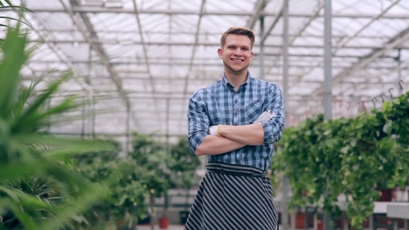 Florist With Arms Crossed In Greenhouse