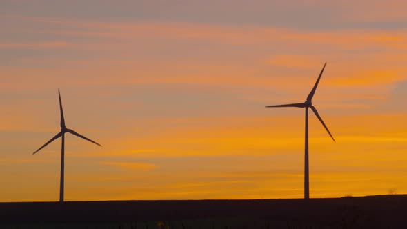 beautiful wind turbines with orange glowing evening sky - multishot