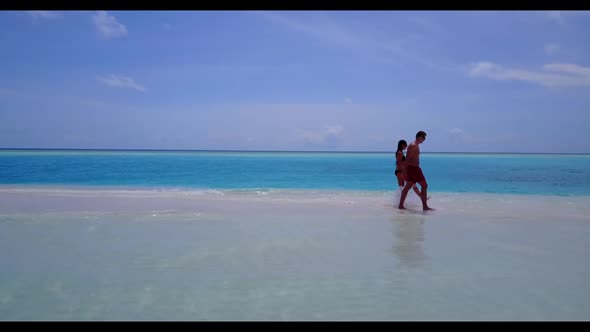 Boy and girl engaged on idyllic lagoon beach lifestyle by clear water and clean sandy background of 