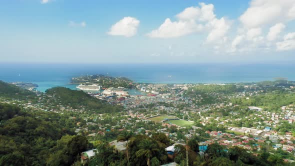 Drone camera taking the town in a dense forest from a cliff (Rodney Bay, Saint Lucia)