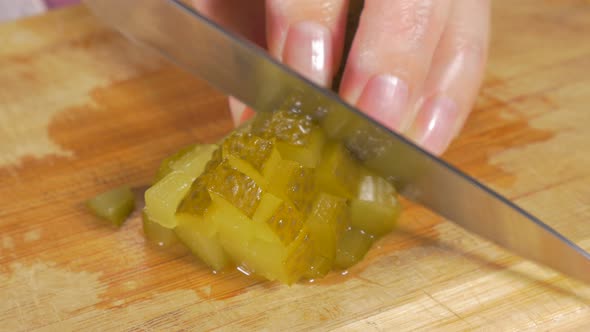 Pickled cucumber chop up smaller pieces  with knife on wooden board 4K 2160p UHD panning footage - G