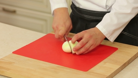 Chef Cutting Up An Onion With a Knife