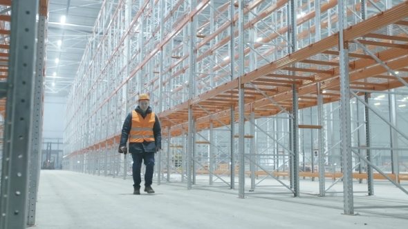 Worker Comes In Bright And Modern Warehouse