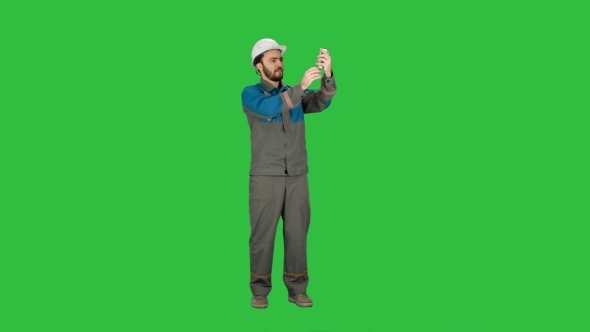 Construction Engineer Makes Selfie On The Phone. Green Screen, Chroma Key.