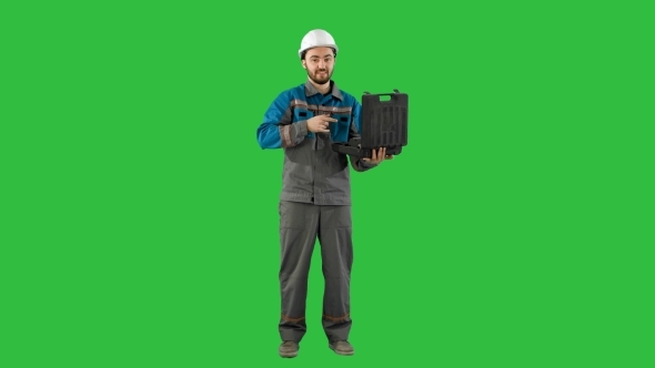 Worker Shows Tools On Camera. Green Screen, Chroma Key.