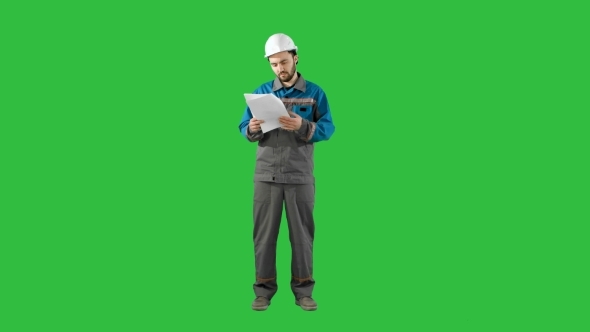 Engineer Man Verify And Read Files Documents On a Green Screen, Chroma Key.