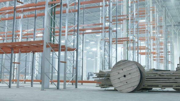 Worer Rolls Coils With Wires In Modern Industrial Warehouse