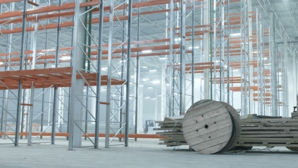 Worer Rolls Coils With Wires In Modern Industrial Warehouse alt
