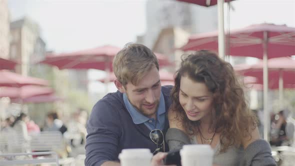 Couple at outdoor cafe posing for selfie