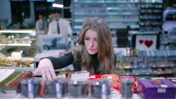 Beautiful Girl Selects Products In Supermarket