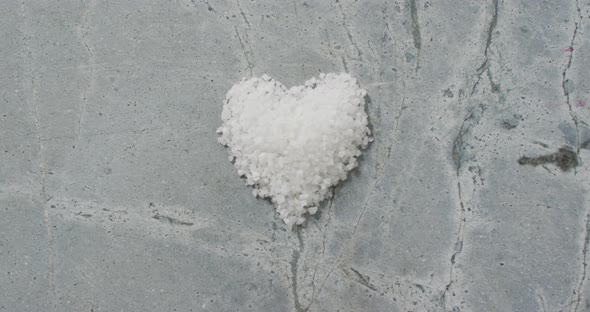 Video of pile of salt in shape of heart on stone kitchen worktop