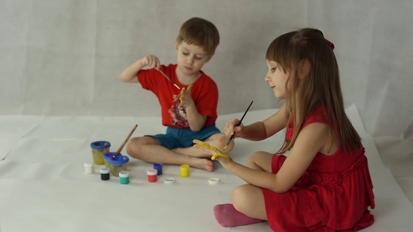 Children Draw on Paper with Brushes, Palms and Gouache