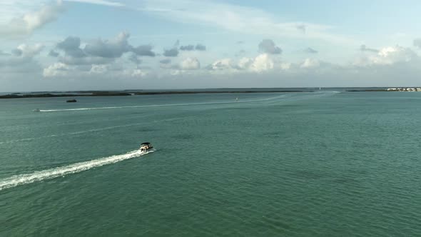 Aerial video of a pontoon boat traveling in the keys towards natural islands off the coast