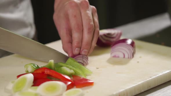 Close Up Shot of the Chef's Hands, He Cuts a Red Onion Into Pieces