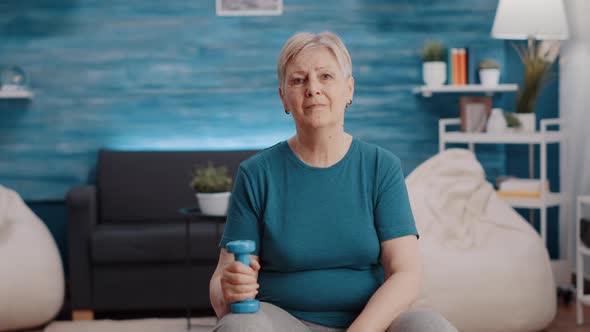 Portrait of Senior Woman Holding Dumbbells at Home