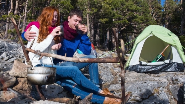 Couple Of Tourists Relaxing Outdoors With Backpacks And Camp