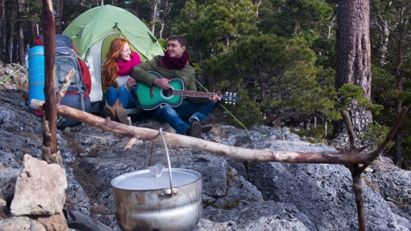 Couple Of Tourists Relaxing Outdoors With Backpacks And Camp