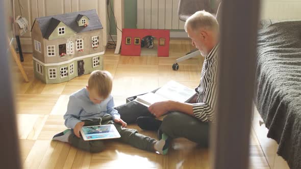 Grandpa Looks Photo Album with His Wedding, Little Boy Using Electronic Tablet