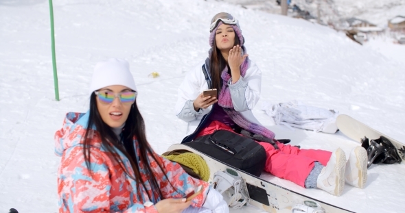 Two Attractive Women Snowboarders Relaxing