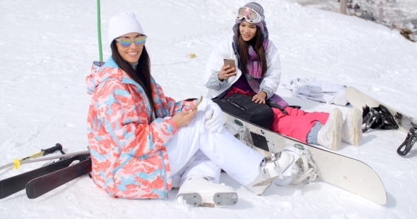 Two Attractive Women Snowboarders Relaxing