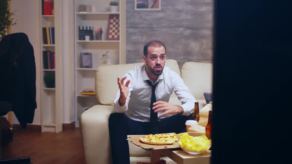 Revealing Shot of Businessman in Suit Watching a Game