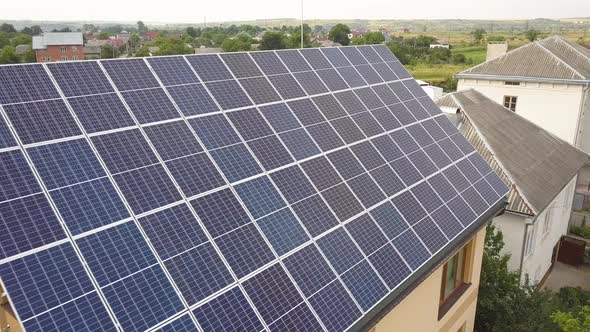 Aerial top view of new modern residential house cottage with blue shiny solar photo voltaic panels