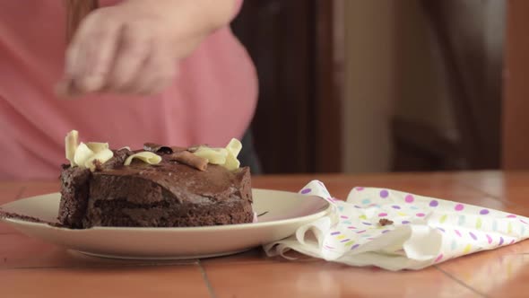 Woman serving piece of chocolate cake wide shot