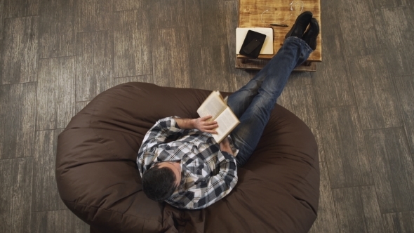 Man With The Book In Hand Sitting On a Chair alt