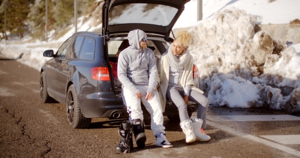 Couple Talking As They Put On Skiing Boots