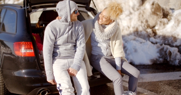 Couple Talking As They Put On Skiing Boots