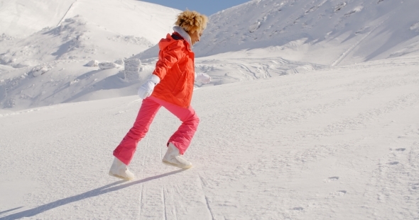Person In Snowsuit Running Up Mountain alt