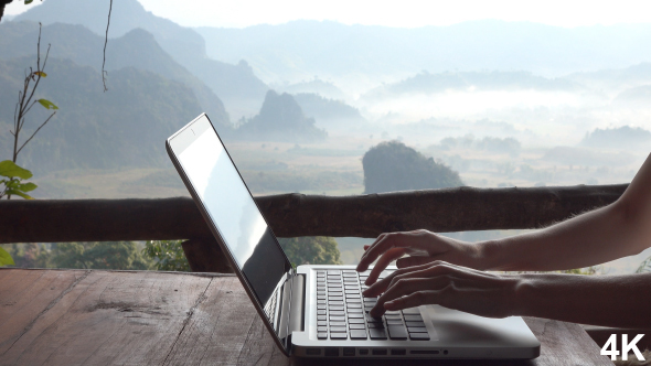 Woman Using Laptop Computer On Mountain Background alt