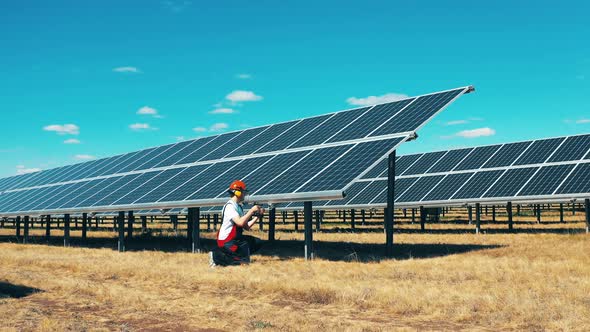 Worker Is Repairing Batteries at the Solar Electric Plant