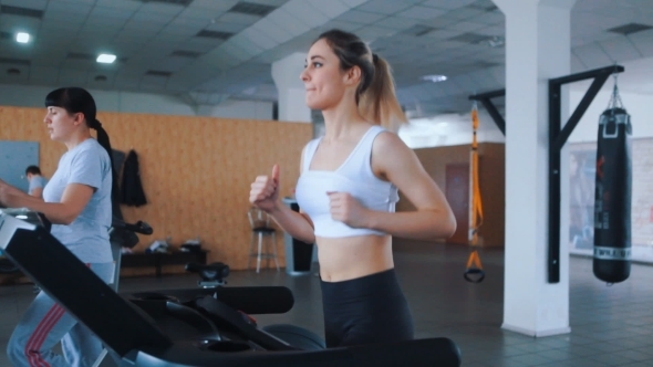 Pretty Girl Running On a Treadmill In a Gym