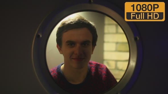 Man Looks in Round Window