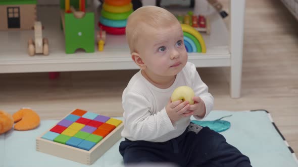 Kid Eats an Apple Sitting on the Floor and Watching Tv