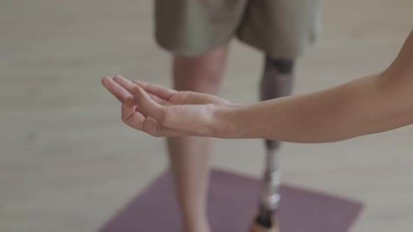 Man with Prosthetic Leg Meditating on Yoga Mat Indoors