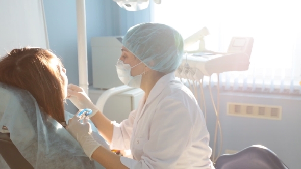 Woman Dentist Working At Her Patients Teeth