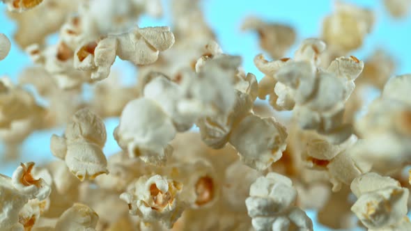 Super Slow Motion Shot of Popcorn on Blue Background After Being Exploded at 1000Fps.