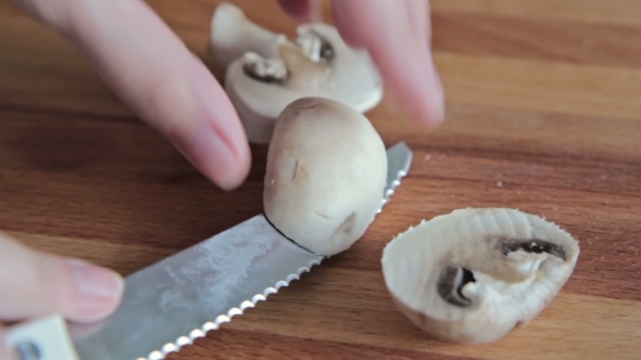 Woman's Hands Cutting Mushroom Champignon