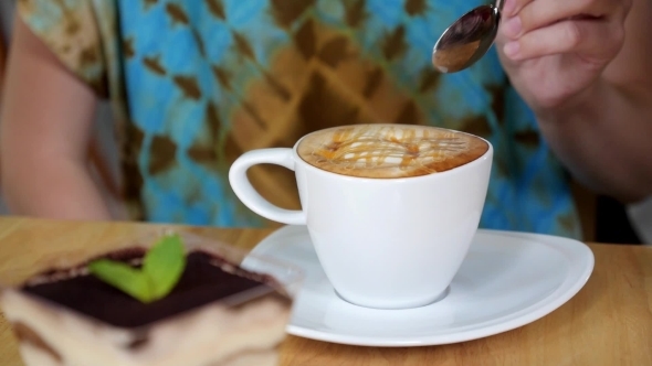 Woman Drinking a Cup Of Cappuccino Coffee With Thick Froth