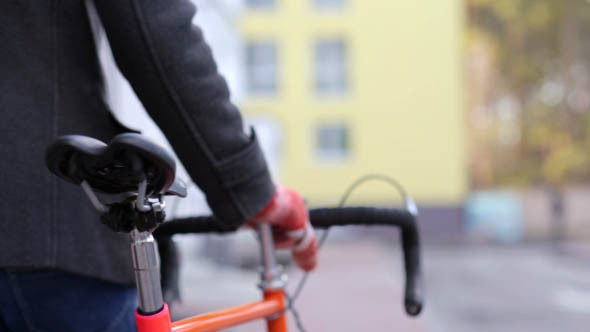  A Man Walks Down the Street with a Bicycle